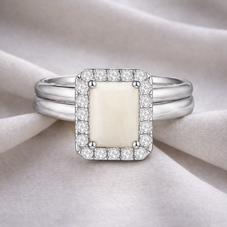 Silver ring with a rectangular pure breastmilk stone on a beige fabric background